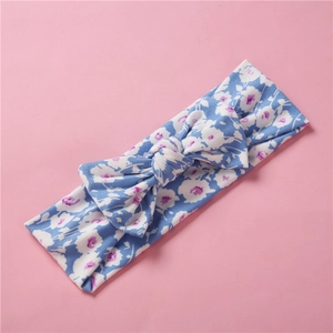 Détail du bandeau extensible en coton bleu à fleurs pour bébé avec un grand nœud