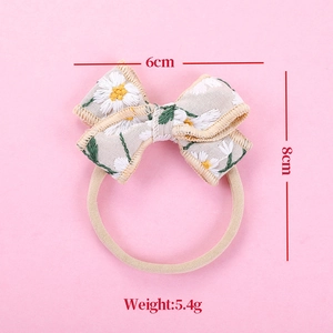 Detail view of cotton linen daisy embroidery bow headband with 6cm and 8cm dimensions