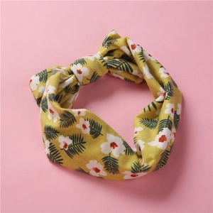 Bandeau bébé élastique à fleurs avec nœud jaune sur un doux fond de couleur rose