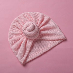 Detail von hellrosa Baby Turban Mütze mit Lochstrickmuster und Donut-Knoten-Design