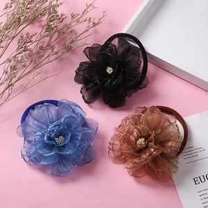 Detailed macro view of chiffon flower headbands with pearl centers in black blue and tan