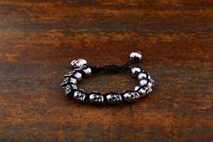 Detail of vintage punk skull beads on black woven cord with adjustable metal clasp