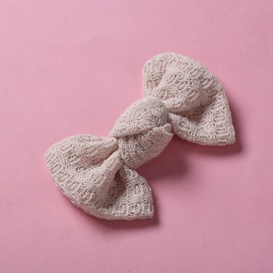 Gros plan sur la barrette nœud tricotée beige avec texture de laine détaillée