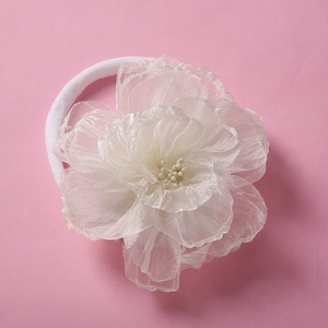 Detailed close-up of large white organza flower headbands with elastic nylon hair bands