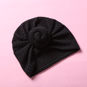 Detail der Waffelstruktur und des Knotens der schwarzen Strickmütze für Babys