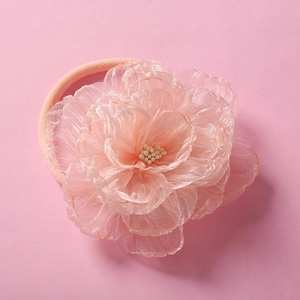 Macro view of pink chiffon flower headband with pearly bead center for baby girls