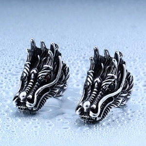 Close-up of dragon head rings in vintage steel with red and black stone inlay details