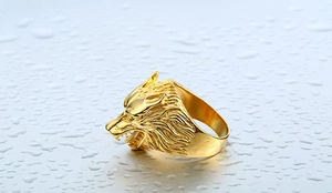 Detailed macro shot of the golden wolf head ring showing intricate carved fur textures
