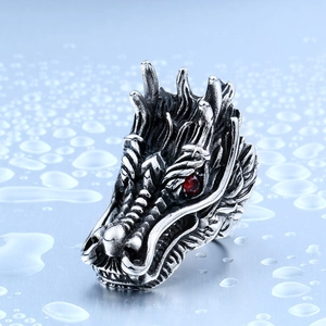 Macro shot of a vintage silver dragon ring with intricate details and red gem eyes