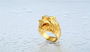 Macro close-up showing the intricate wolf head design on the golden stainless steel ring
