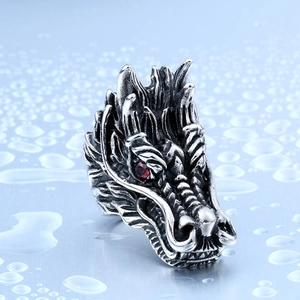Close-up of dragon head ring in vintage steel with detailed scales and red zircon eyes