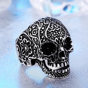 Vintage stainless steel skull ring with intricate floral carvings and sugar skull design