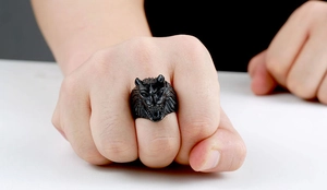 Detailed macro shot of a men's matte black stainless steel ring with 3D wolf head carving