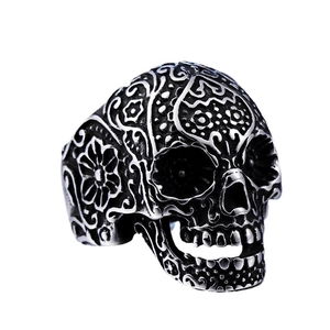 Vintage stainless steel skull ring featuring intricate floral carvings and dark oxidized finish