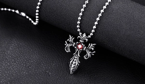 Makro-Detail des gotischen Drachenkreuz-Anhängers mit Vintage-Silber und rotem Edelstein