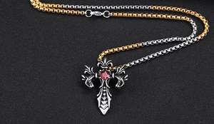 Makro-Detail des gotischen Drachenkreuz-Anhängers mit rotem Stein und Kette