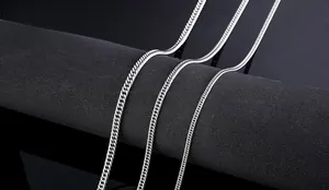 Detailed view of three silver stainless steel cuban curb chains on black display