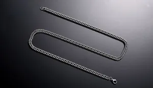 Detailed view of silver flat curb chain in stainless steel with secure lobster clasp