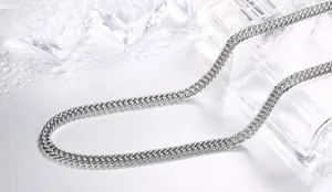 Detailed view of heavy titanium steel flat curb chain on ice cubes with water drops