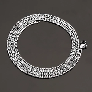 Detailed view of silver titanium steel flat Cuban link chain with lobster clasp on black background
