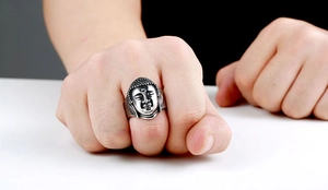 Detailed view of a vintage stainless steel Buddha head ring worn on a finger