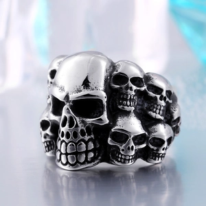 Macro detail of vintage stainless steel punk ring featuring multi-skull design and aged finish