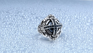 Macro d'une bague croix gothique vintage avec pierres de zircon noir et détails de texture