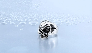 Detaillierte Nahaufnahme eines Punk-Totenkopf-Rings in Vintage-Silber mit Wassertropfen