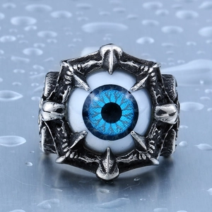 Dettaglio anello punk in acciaio inossidabile con occhio blu e artigli metallici