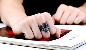 Close-up of vintage skull ring with flower engraving on a male model's hand