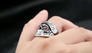 Macro shot of a gothic skull ring with red gems on a model's hand with punk style
