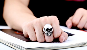 Close-up of vintage stainless steel skull ring with punk style worn on hand