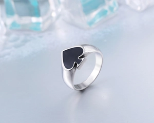 Macro shot of stainless steel ring with spade motif and black enamel finish inlay
