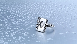 Macro detail of stainless steel ring featuring spade motif and sharp metal claws design