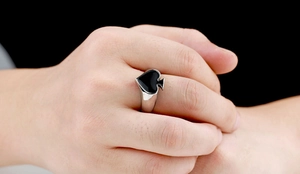 Detail of spade emblem with black enamel finish on polished stainless steel ring