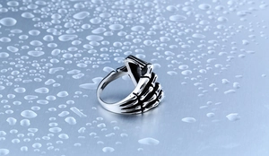 Detail of gothic punk skull hand ring in titanium steel with vintage black finish