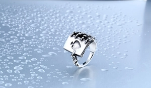 Macro detail of gothic stainless steel ring featuring spade and skeleton hand with water drops