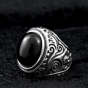 Macro detail of retro steel ring with black oval stone and side floral relief