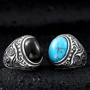 Macro detail of retro steel rings featuring engraved patterns with turquoise and onyx stones