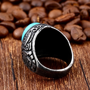 Macro detail of vintage steel ring with blue turquoise stone on rustic wood background