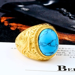 Macro shot of vintage titanium steel ring with oval blue turquoise and ornate engraving