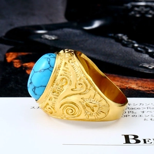 Detailed close-up of a vintage gold ring with turquoise gemstone and ornate carvings