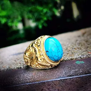 Detailed macro view of retro men's steel ring with blue stone and floral engraving