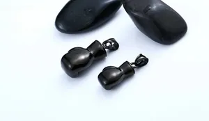Polished black stainless steel boxing glove pendants on smooth stones for men