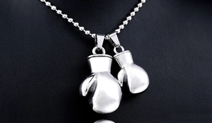 Detailed macro view of polished stainless steel boxing glove pendants on a ball chain