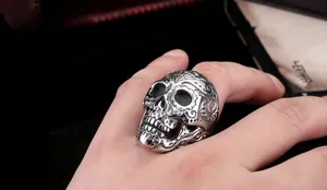 Macro detail of gothic skull ring with vintage engraved texture in matte steel finish