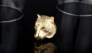Macro shot of gold tiger head ring with detailed engraving and shiny metallic finish