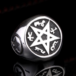 Macro de bague gothique en acier avec sceau pentagramme et runes occultes sur fond noir