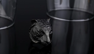 Detailed close-up of a carved tiger head ring in antique grey steel finish