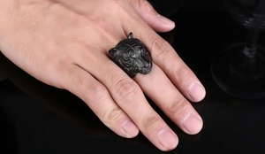 Detailed view of a vintage black tiger head ring with fine textures on a male hand